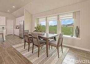 Garland house for rent - A dining room with a table and chairs and a refrigerator in the background.