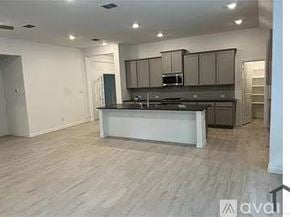 Garland house for rent - A kitchen with a white island and wooden floors.