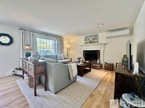Brewster house for rent - A living room with a grey couch, a fireplace, and a television.