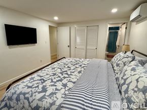 Brewster house for rent - A bedroom with a large bed and a flat screen TV mounted on the wall.