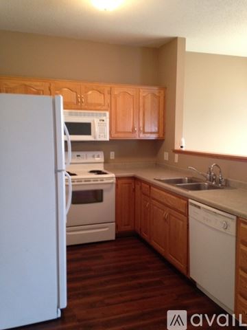 North Mankato townhouse for rent - A kitchen with white appliances and wooden cabinets.