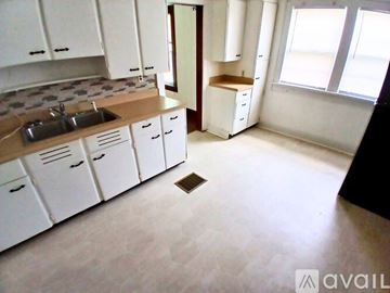 Muncie house for rent - A kitchen with white cabinets and a sink.
