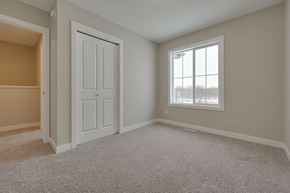 Edmonton apartment for rent - A room with a white door and a window with a view of trees outside.