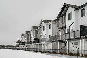 Edmonton apartment for rent - A row of houses with balconies and fences in front.