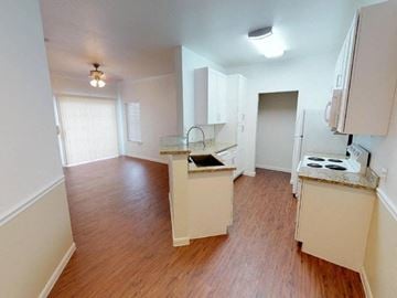 Victoria apartment for rent - A kitchen with white cabinets and a wooden floor.
