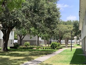 Victoria apartment for rent - A tree-lined pathway in a grassy area with a building in the background.