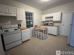 New Orleans townhouse for rent - A kitchen with white appliances and cabinets.