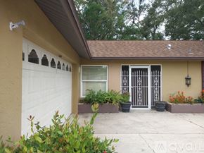 Sarasota house for rent - A house with a white garage door and a brown roof.