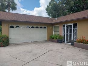Sarasota house for rent - A house with a white garage door and a brown roof.