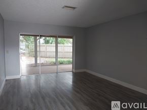 Sarasota house for rent - A room with wooden floors and a sliding glass door leading outside.