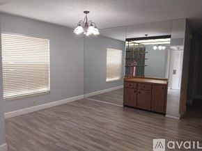 Sarasota house for rent - A room with wooden flooring and a cabinet under a mirror.