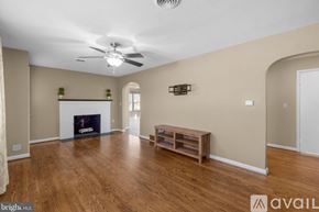 Hagerstown house for rent - A spacious living room with a fireplace and a ceiling fan.