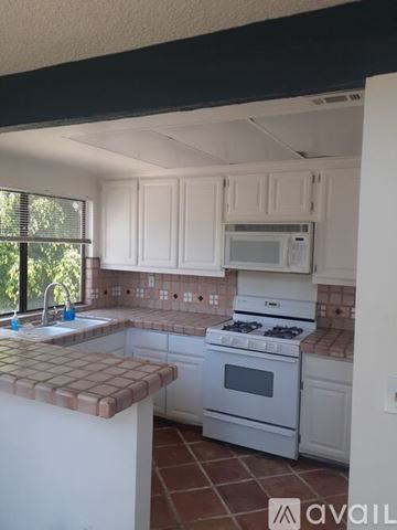 Los Angeles condo for rent - A kitchen with white cabinets and a white stove.