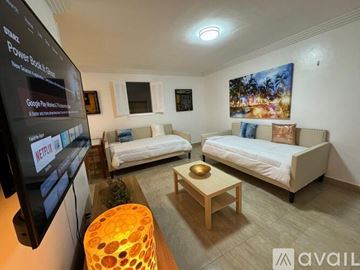 Miami Beach condo for rent - A living room with two couches, a coffee table, and a television displaying Netflix.