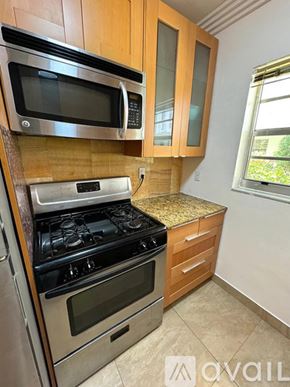 Miami Beach condo for rent - A kitchen with wooden cabinets and a stainless steel oven.