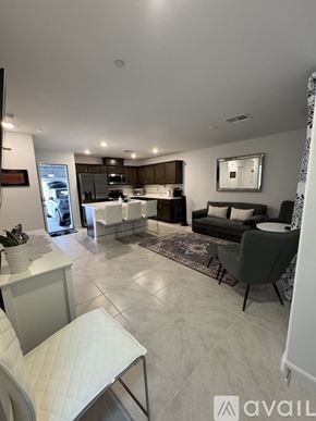 Las Vegas townhouse for rent - A modern living room with a kitchen in the background.