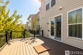 Ashburn apartment for rent - A wooden deck with a black railing and a small table in the middle.