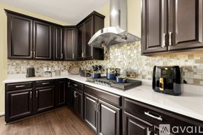 Ashburn apartment for rent - A kitchen with dark brown cabinets and a white countertop.