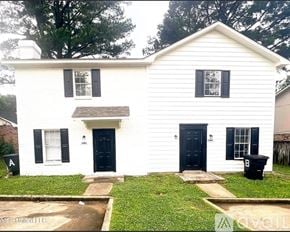 Jackson townhouse for rent - A white house with a black door and windows.