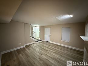 Jackson townhouse for rent - A room with wooden flooring and a staircase leading to another room.