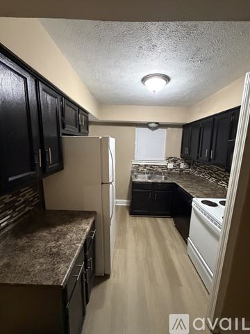 Jackson townhouse for rent - A kitchen with black cabinets and a refrigerator.