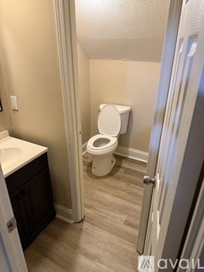 Jackson townhouse for rent - A bathroom with a toilet, sink, and cabinet.