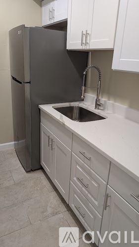 St. Petersburg apartment for rent - A kitchen with a black refrigerator and white cabinets.