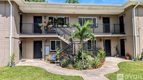 St. Petersburg apartment for rent - A balcony with a black railing and a palm tree in front of a building.