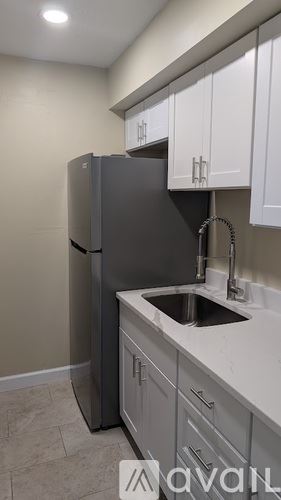 St. Petersburg apartment for rent - A kitchen with a grey fridge and white cabinets.