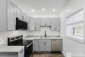 Ypsilanti house for rent - A kitchen with white cabinets and a granite countertop.