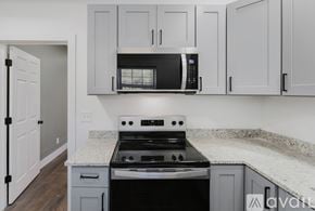 Ypsilanti house for rent - A kitchen with a black microwave above a stove.