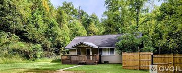 Candler house for rent - A kitchen with wooden cabinets and a black refrigerator.