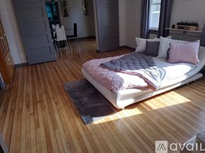 Oshkosh apartment for rent - A bedroom with a bed, wooden floor, and a rug.