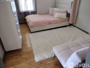 Oshkosh apartment for rent - A bedroom with a pink bed and a white rug.