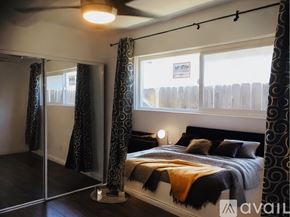 San Diego house for rent - A bedroom with a bed, curtains, and a mirror.