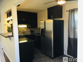 San Diego house for rent - A kitchen with black cabinets and a black refrigerator.
