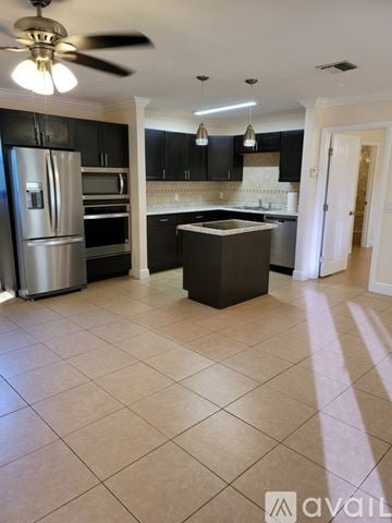 Boynton Beach condo for rent - A kitchen with black cabinets and a silver refrigerator.