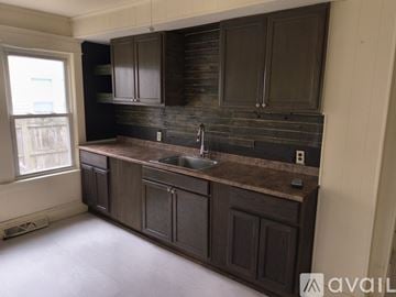 Chicopee apartment for rent - A kitchen with dark brown cabinets and a granite countertop.