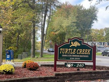 State College apartment for rent - A sign for Turtle Creek Studio, 1-2 & Bedroom Apartments with a phone number on it.