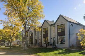 Edmonton apartment for rent - A modern building with a large tree in front of it.