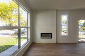 Edmonton apartment for rent - A modern living room with a fireplace and large windows.