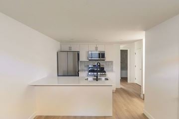 Edmonton apartment for rent - A kitchen with a white countertop and a microwave above it.