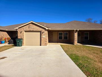 Calera house for rent - A house with a brown roof and a garage door.