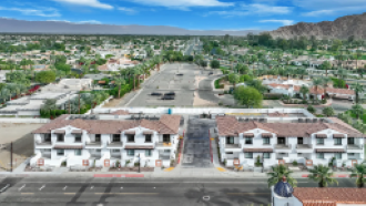 La Quinta apartment for rent - A large white building with a red roof is in the center of a parking lot.
