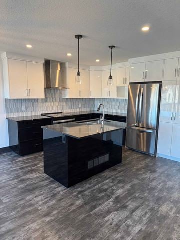 London house for rent - A modern kitchen with a black island and stainless steel appliances.