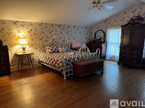 Wilson apartment for rent - A bedroom with a bed, dresser, and a ceiling fan.