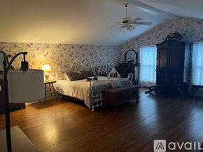 Wilson apartment for rent - A bedroom with a bed, dresser, and ceiling fan.