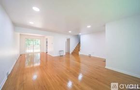 Cresskill house for rent - A spacious room with wooden floors and a staircase.