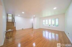 Cresskill house for rent - A spacious room with wooden floors and a staircase.