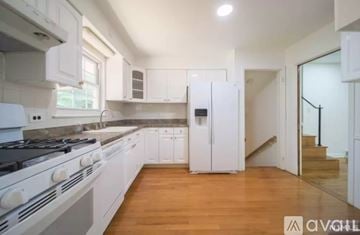 Cresskill house for rent - A modern kitchen with white appliances and wooden floors.